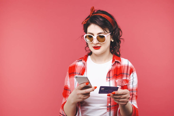 Όμορφη γυναίκα κρατώντας πιστωτική κάρτα και το τηλέφωνο για να κάνετε αγορές σε απευθείας σύνδεση - Φωτογραφία, εικόνα