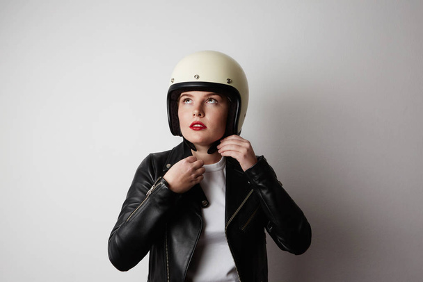 Young biker woman posing o the white background. Isolated. - Foto, Imagem
