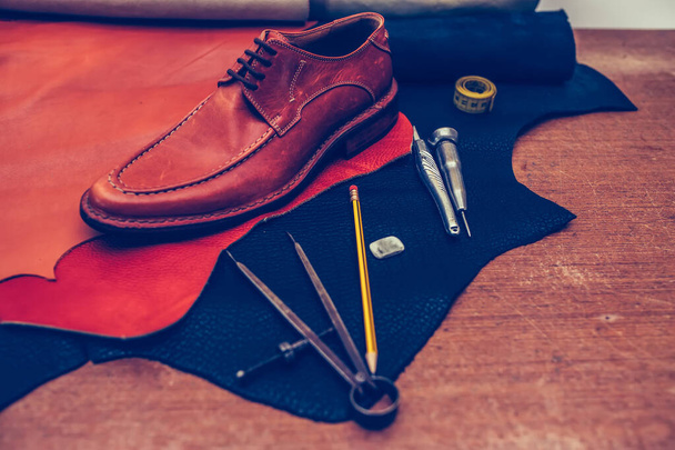 Klasik kahverengi ayakkabılar ve deri ayakkabı yapma aletleri. - Fotoğraf, Görsel