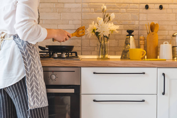 woman fry on pan kitchen view - Foto, afbeelding