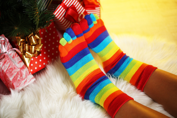 Legs in socks near Christmas tree on carped - Zdjęcie, obraz