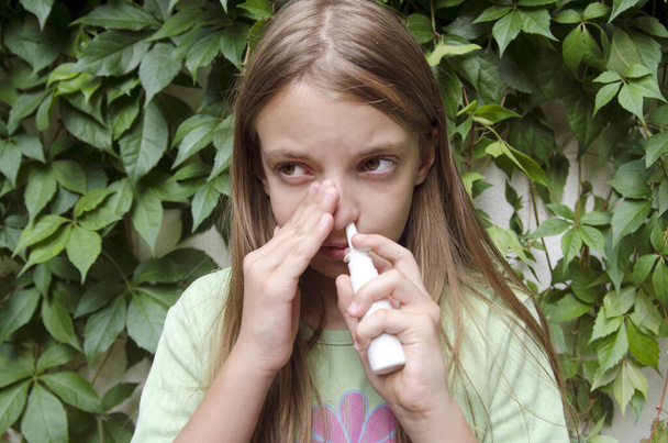 Маленькая девочка с синусом проблемы со здоровьем с помощью носовой sprey.Sinusitis боль и душистый нос - Фото, изображение