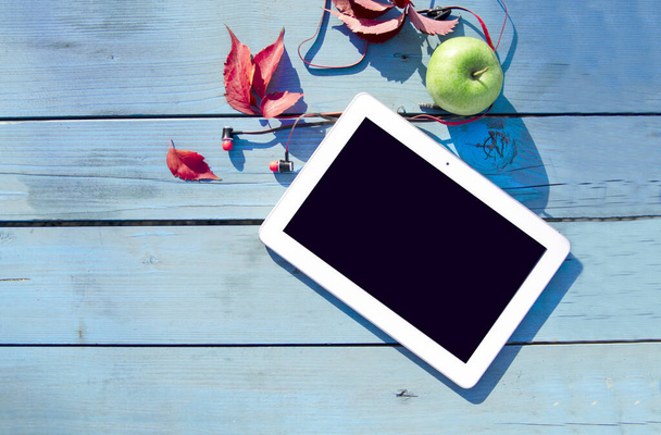 bloc de notas pantalla negra en blanco en tablero de madera azul y manzana verde, vista superior
 - Foto, imagen