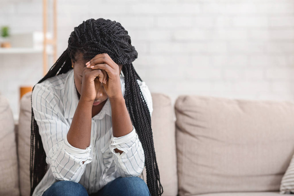 verzweifelte schwarze Mädchen sitzt allein auf Sofa zu Hause - Foto, Bild