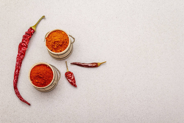 Magyar (Hungarian) red sweet and hot paprika powder. Traditional seasoning for cooking national food, different varieties of dry pepper. Wooden kegs, stone concrete background - Foto, Imagem