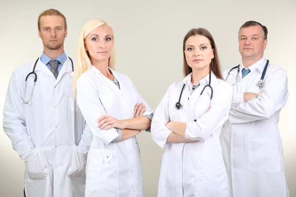 Medical workers on grey background - Фото, изображение