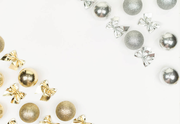 Gold and silver Christmas balls nd bow on white background. White copy space for your text and logo. - Zdjęcie, obraz