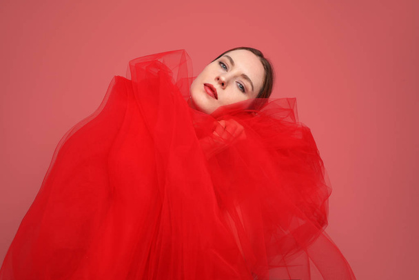 Stylish young woman posing in the studio. Close-up portrait. Red background. - Φωτογραφία, εικόνα