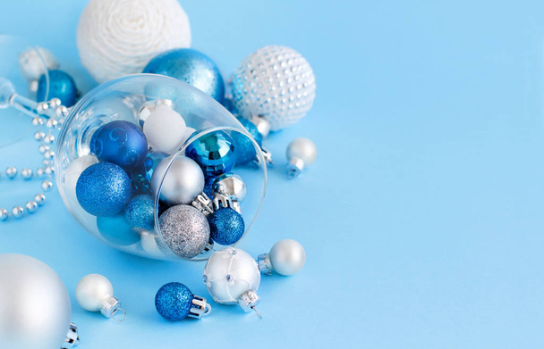 Bola de Navidad en una copa de vino sobre un fondo azul claro
 - Foto, imagen
