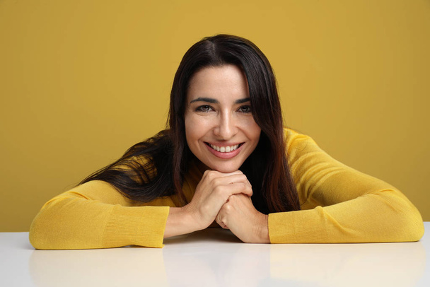 Young woman smiling and posing on the yellow background. - Fotoğraf, Görsel