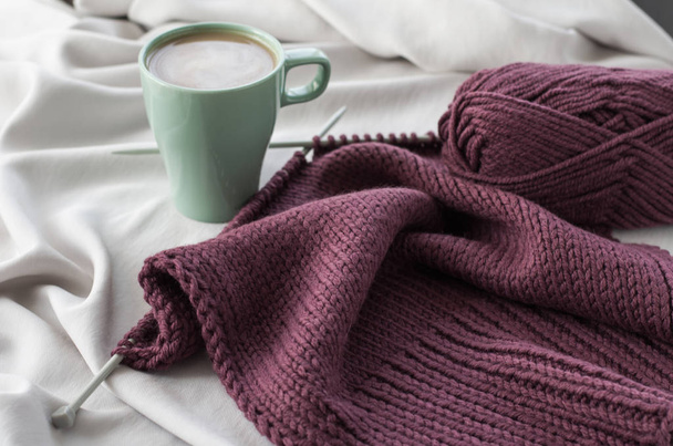 Cup of coffee on the background of burgundy knitting - Foto, Imagen