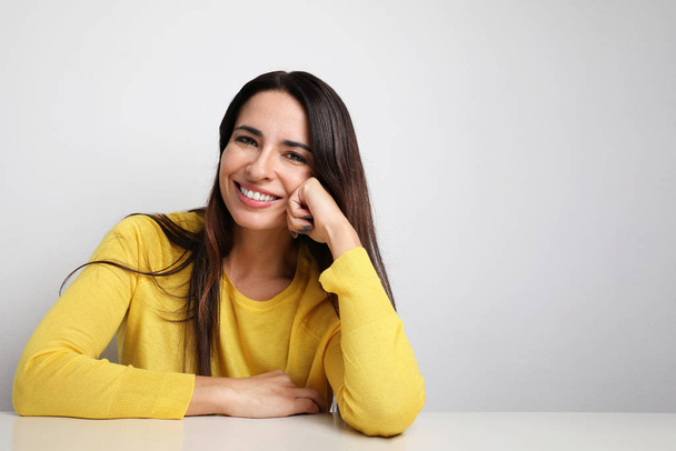 Attractive woman smiling and wearing yellow sweater posing on the white background. Isolated. - Фото, изображение