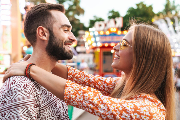 Loving couple walking outdoors in amusement park - Fotó, kép