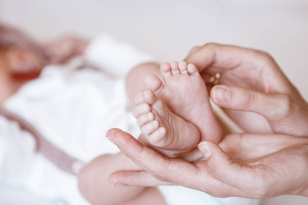 Yeni doğmuş bebeğin ayakları kadın ellerinde, yakın plan.. - Fotoğraf, Görsel