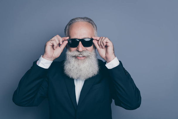Close-up portrait of his he nice attractive chic classy brutal cool modern trendy cheerful cheery gray-haired man touching specs isolated over dark grey pastel color background - Foto, imagen