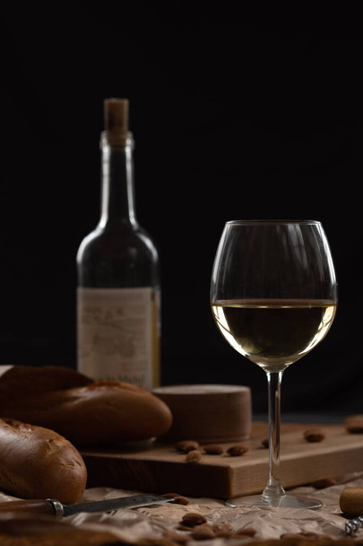 A glass of white wine and cheese on a blackboard - Photo, Image