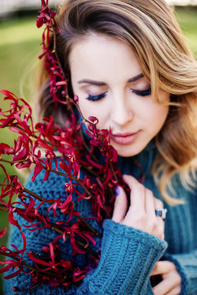 Beautiful woman with flower near face - Foto, afbeelding