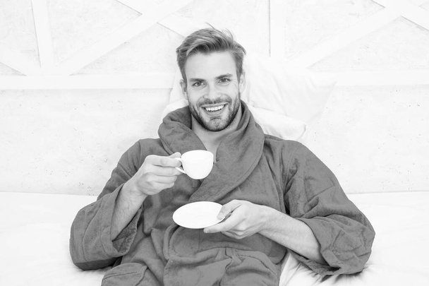 Enjoy morning coffee. Happy morning. Handsome man drink morning coffee. Happy bearded man in bed. Good mood. Starting day with good coffee. Relaxing at home. Pleasant moments. Gourmet espresso - Fotografie, Obrázek