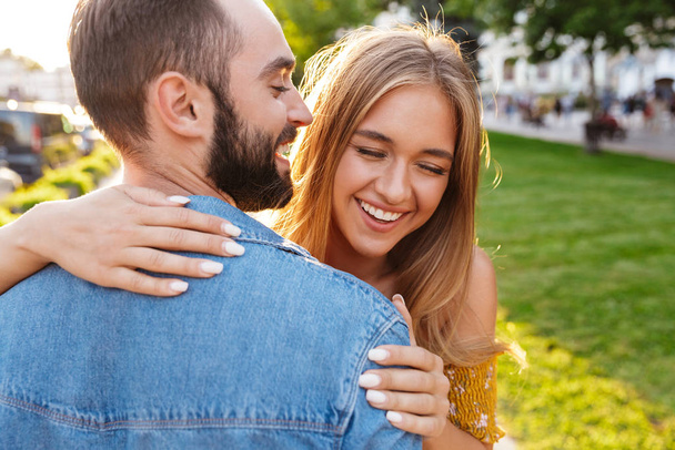 Happy lovely young couple in love spending time outdoors - Фото, изображение