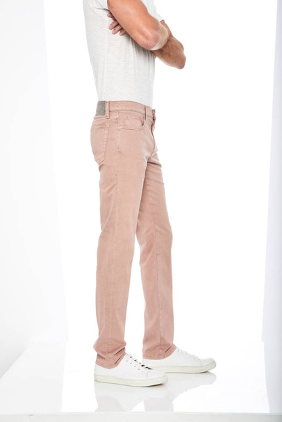 Slim fit barevné kalhoty spárované s bílou tričko a bílé tenisky s bílým pozadím - Fotografie, Obrázek