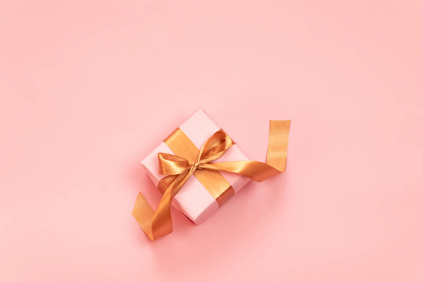 Поздравительная открытка с подарком или подарком на розовом фоне. Плоская композиция на день рождения, День матери, с Рождеством и Новым годом
 - Фото, изображение