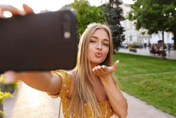 Beautiful smiling young blonde girl taking a selfie - Foto, Imagem