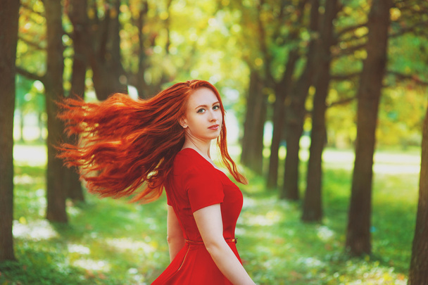 όμορφη γυναίκα με κόκκινο φτερουγίσματα μαλλιά - Φωτογραφία, εικόνα