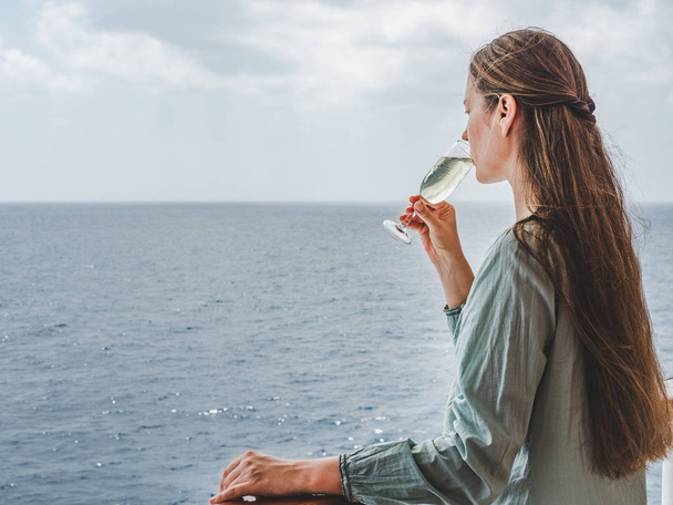 Woman holding a glass on the deck - Foto, immagini