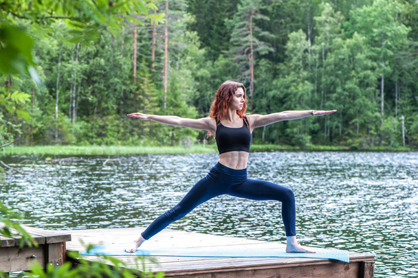 Young yogi  girl  practicing yoga, standing in Warrior two exerc - Foto, immagini