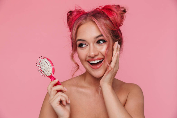 Portrait of shirtless young woman smiling and holding hair brush - Photo, Image
