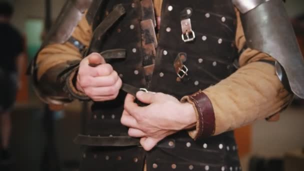 Miehet pukemassa ritarin haarniskaa pukuhuoneeseen - takin pukeminen
 - Materiaali, video
