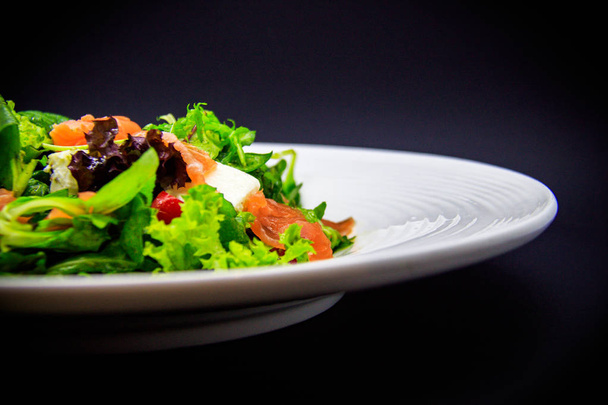 Salmon salad on black background - Photo, Image