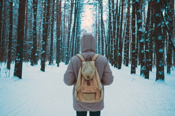 молодой человек в зимнем заснеженном лесу
 - Фото, изображение