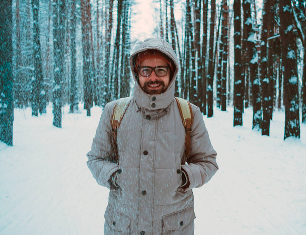 young man in a winter snowy forest - Photo, Image