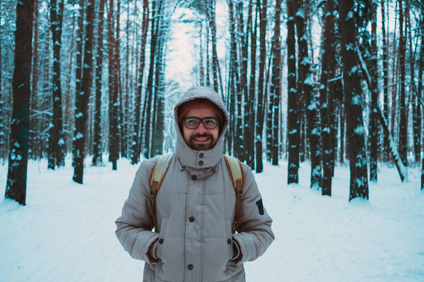 νεαρός σε χειμερινό χιονισμένο δάσος - Φωτογραφία, εικόνα