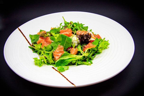 Salmon salad on black background - 写真・画像