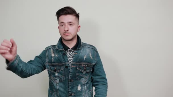 Jóképű kaukázusi fiatalember tartja a kezét a fején, egyenesen - Felvétel, videó