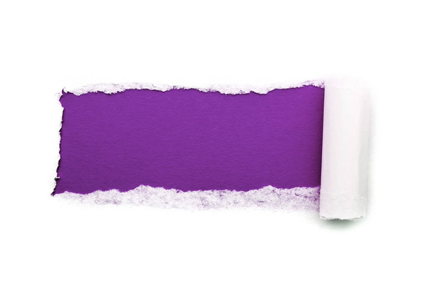A hole in white paper with torn edges isolated on a white background with a bright violet color paper background inside. Good sharp paper texture. - Foto, Imagem