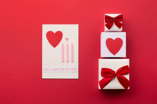 Caixas de presente embrulhado artesanal, corações vermelhos e velas, backgro vermelho
 - Foto, Imagem