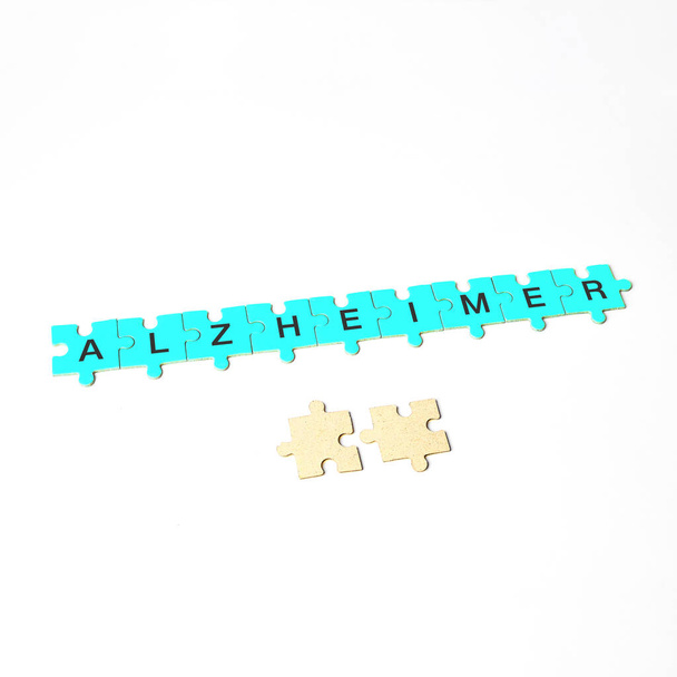 Alzheimer hastalığı, Alzheimer kelimesi sarı, mavi ve mavi bulmacalardan oluşur. - Fotoğraf, Görsel