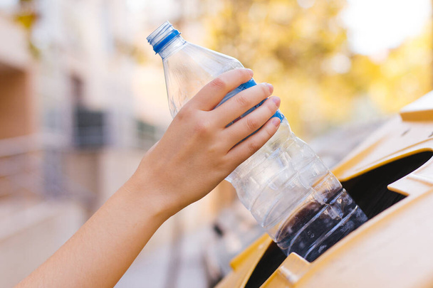 Archivbild einer Frauenhand beim Recycling einer Plastikflasche - Foto, Bild