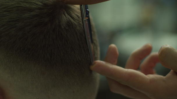Close up of mans hair cutting by barbers scissors and comb in slow motion. Mans hands making male haircut in salon.  - Filmagem, Vídeo