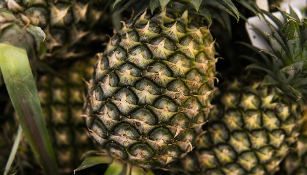 Hodně ananasového ovoce na trhu v asijské zemi. Pozadí textury z ananasu. Tropické a exotické ovoce. Zdravé a vitamínové potraviny koncepce. - Fotografie, Obrázek