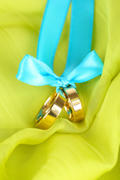 Wedding rings tied with ribbon on bright fabric - Photo, Image