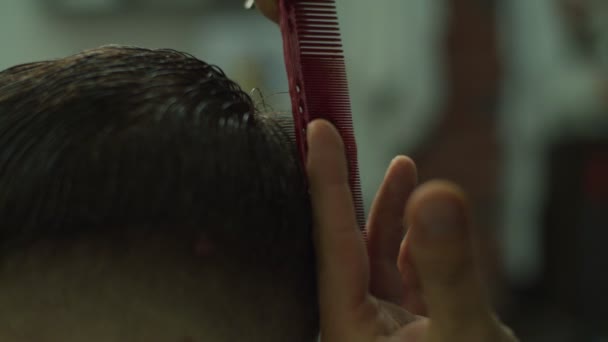 Close up of mans hair cutting by barbers scissors and comb in slow motion. Mans hands making male haircut in salon.  - Metraje, vídeo