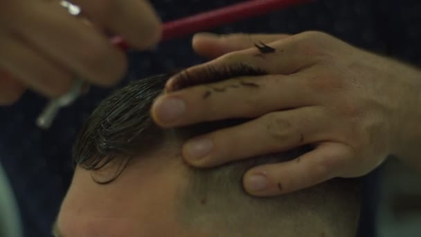 Close up of mans hair cutting by barbers scissors and comb in slow motion. Mans hands making male haircut in salon.  - Imágenes, Vídeo
