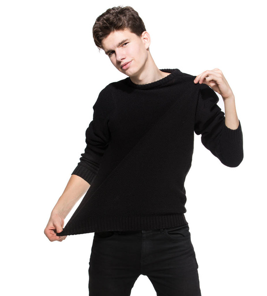 Jonge man model in zwarte kleren poseren in studio witte achtergrond. Blanke man in stijlvolle kleding trui en jeans isoleren. Fashion model jonge blanke man - Foto, afbeelding
