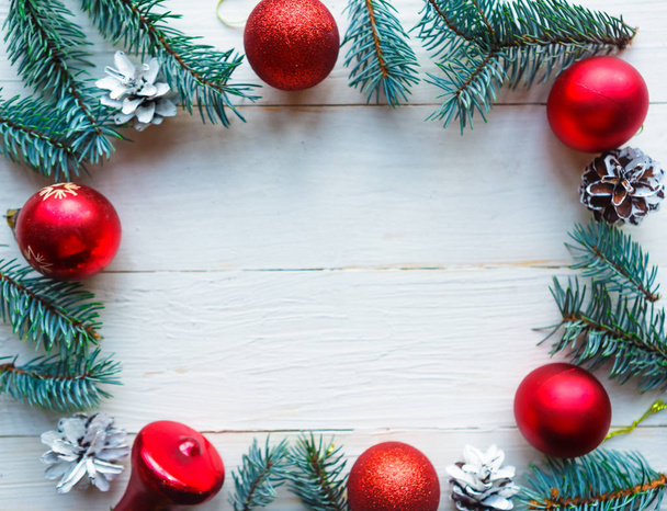 Rahmen aus Christbaumzweigen und roten Kugeln auf weißem Holzgrund. Weihnachtsgrußkarte. Raum für Ihren Text - Foto, Bild