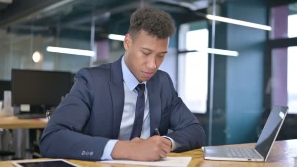 Serious Young Businessman doing Paperwork in Office  - Felvétel, videó
