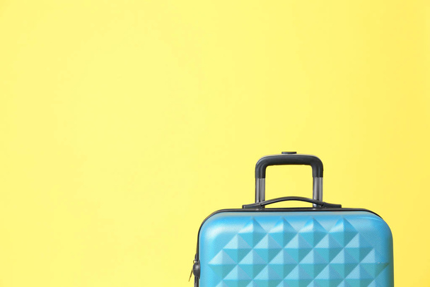 Stylish blue suitcase on yellow background. Space for text - Zdjęcie, obraz